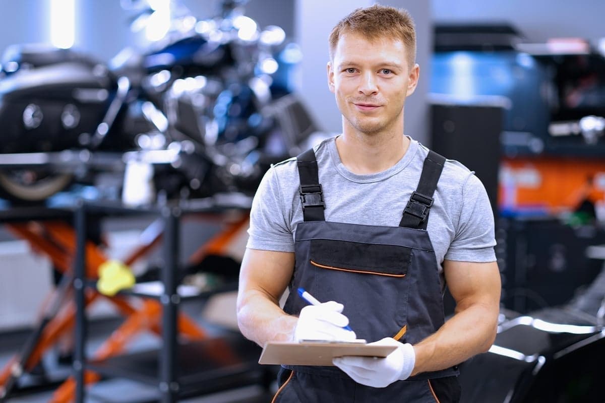 Mechanic reviewing job notes on a clipboard